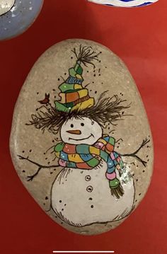 a rock with a snowman painted on it