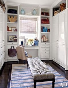 an image of a room with white cabinets and furniture in it, including a bench