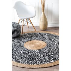 a black and white area rug with an oval design on the center in front of a chair