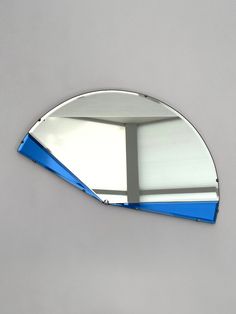 a mirror that is on the wall with a blue strip around it's edge