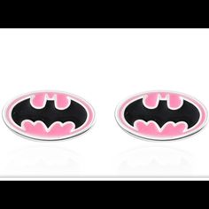 pair of pink and black batman cufflinks on white background with reflection in the middle