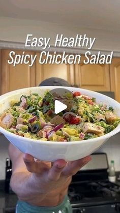 a person holding up a bowl of food in their hands with the words easy, healthy spicy chicken salad