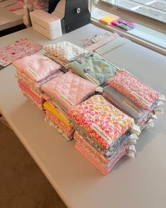 a table topped with lots of different types of quilts and fabrics on top of it