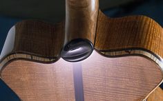 a close up of a guitar neck with a light shining on it's side