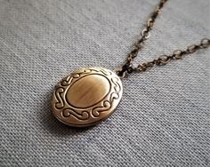 "Lovely photo locket necklace features a small antique brass locket in oval shape. Locket pendant hang on fancy brass chain. Great for wearing alone or layering with other necklace Locket size: 1\" (including loop) X 0.7\" Purchase over $40 enjoys free shipping! Coupon code 'freeshipping1'. Free Gift Wrapping on request - All items that are gift wrapped come in with a kraft box with raffia string and blank writing card. Please leave a note if you need it upon ordering." Antique Gold Handmade Pendant Locket Necklace, Ornate Brass Pendant Locket Necklace, Handmade Brass Locket Necklace For Vintage Collection, Antique Gold Locket Necklace In Brass, Vintage Brass Necklace With Oval Pendant, Handmade Gold Oval Pendant Locket Necklace, Vintage Brass Medallion Necklace As Gift, Ornate Gold Locket Necklace In Brass, Brass Oval Pendant Necklace With Engraving