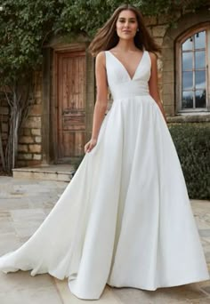 a woman in a white wedding dress standing outside