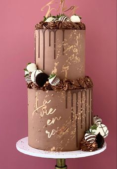 a three tiered cake with chocolate frosting and decorations on top that says i love you