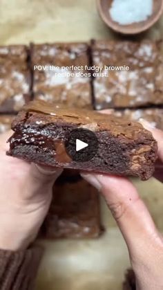 a person holding a piece of brownie in their hand