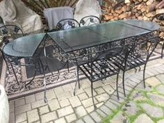 an outdoor table and chairs are set up on the brick patio with firewood stacked in the background