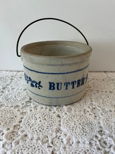 a blue and white bowl sitting on top of a lace covered tablecloth next to a wall