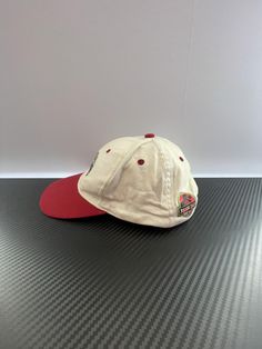 Very Good - Excellent quality. May have very minor imperfections that may or not be visible to the eye. Minor use. This vintage cap features the iconic T-Rex from Universal Studios Parks. With a red bill and white cap, it adds a touch of nostalgia to any outfit. Show your love for the parks with this unique and stylish accessory. FEATURES Classic Red Baseball Cap With Visor, Classic Red Visor Baseball Cap, Retro Red Visor Baseball Cap, Red Cotton Fitted Hat With Curved Brim, Retro Red Hats For Baseball Season, Red Retro Hats For Baseball Season, Red Retro Hat For Baseball Season, Vintage Red Flat Bill Baseball Cap, Vintage Red Snapback Fitted Hat