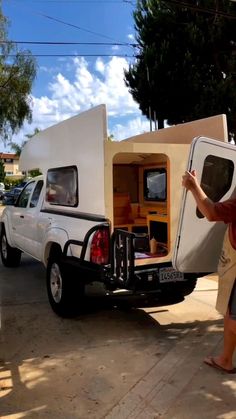 a man is unloading the back of a truck with a camper attached to it