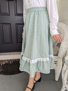 "Ladies small size skirt, made from a vintage Gunne Sax Pattern.  This is a perfect skirt to twirl in ! Plus it has pockets!  Pattern is Simplicity # 5491, from 1982.  Fits a 25\" waist.  Skirt length is 28\". Lying flat, skirt measures : Waist- 13\", Bottom of Ruffle 47\".  Fabric is cotton, green floral.   Has a ruffled edge with lace and  ribbon trim. bottom lace on ruffle is vintage.  Two side pockets, zipper, and a vintage button on waistband." Green Skirt For Daywear, Vintage Ruffled Skirt For Spring, Vintage Long Ruffled Petticoat, Vintage Long Skirt With Relaxed Fit, Spring Cottagecore Skirt With Ruffled Detail, Spring Cottagecore Skirt With Ruffled Hem, Green Full Skirt With Ruffles, Vintage Ruffled Skirt Petticoat, Vintage Long Gathered Skirt Bottoms