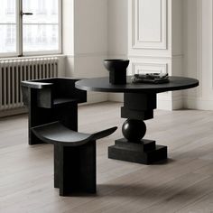 a black table with two chairs and a bowl on it in front of a radiator