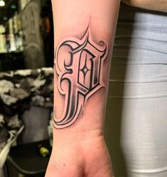 a woman's arm with a tattoo on it that has the letter d in black ink