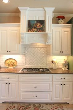 a kitchen with white cabinets and an area rug in front of the stove top oven