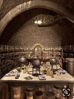 an old wine cellar with lots of bottles on the table and stools around it