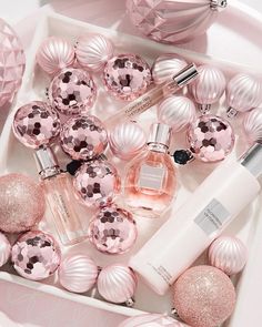 pink christmas ornaments and perfume bottles in a white box