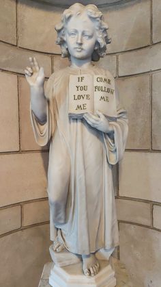 a white statue with writing on it that says if you love me, i'm god