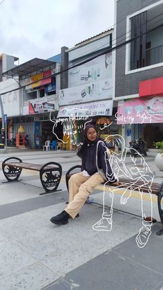 a woman sitting on a bench in front of buildings