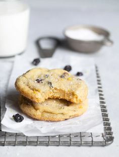 two cookies sitting on top of each other next to a glass of milk