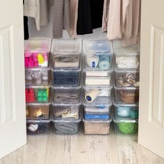 an organized closet with clear plastic containers and clothes hanging on the wall, along with various crafting supplies