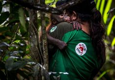 a woman holding a baby in the jungle