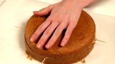 a person is placing their hand on top of a cake