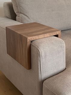 a close up of a couch with a wooden table on it's back end