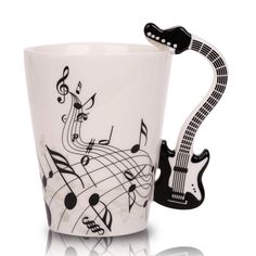 a white coffee cup with musical notes on it and a black guitar shaped mug handle