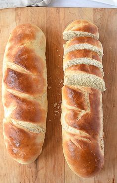 two loaves of bread sitting on top of a cutting board next to each other