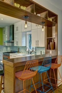 a kitchen with two bar stools next to an island in front of the sink