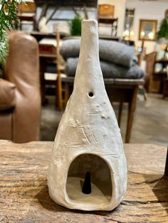 a white vase sitting on top of a wooden table