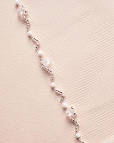 a close up of a necklace with pearls on it