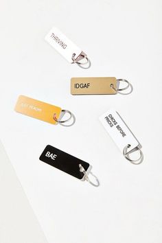 three different name tags are shown on a white surface, one is gold and the other is black