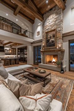 a large living room with stone fireplace and high ceilings