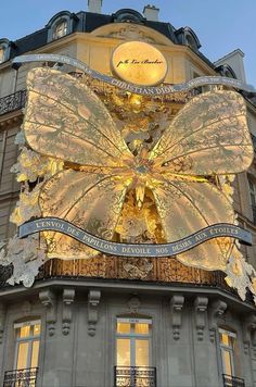 a building with a giant butterfly on it's side and lights in the windows