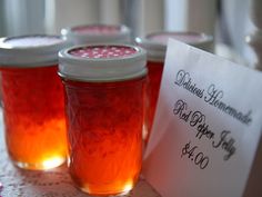 three jars filled with liquid sitting on top of a table next to a paper sign