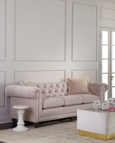 an elegant living room with white walls and pink couches, gold trimmings