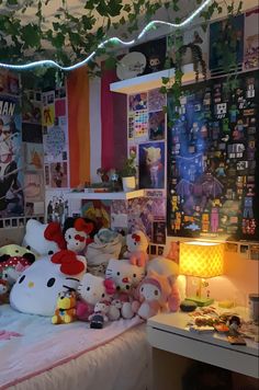 a bedroom with hello kitty stuffed animals and posters on the wall above the bedspread