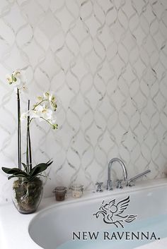 a bathroom with a sink, tub and flowers in the vase on the counter top