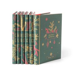 six books in green covers with gold trimmings and holly decorations on the front