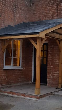 a small wooden building with a black roof