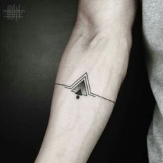 a black and white photo of a person's arm with a triangle tattoo on it