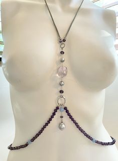 This eye-catching, feminine body chain features a large, faceted amethyst stone as the centerpiece, flanked by lustrous, round, silver-grey pearls, and sparkling purple crystals. A drop-shaped Baroque pearl dangles at the bottom, augmented by pale, sky-blue agate. Draping around the lower torso are more sparkling, faceted purple crystals interspersed with blue agate, all hand-knotted on rich purple silk cord and finished with sturdy silver-plated chain . The upper torso portion features slinky s Silver Crystal Jewelry, Diy Body Chain, Pearl Body Chain, Feminine Body, Waist Jewelry, Silver Bodies, Purple And Silver, Rich Purple