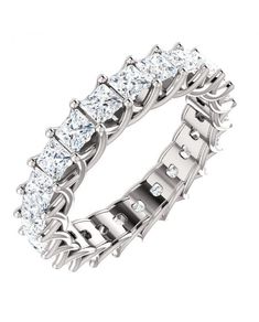 a white gold ring with princess cut diamonds on the sides and four prongs