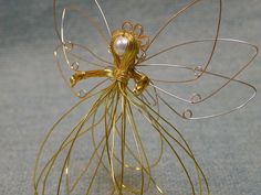 a gold wire angel with pearls on its wings