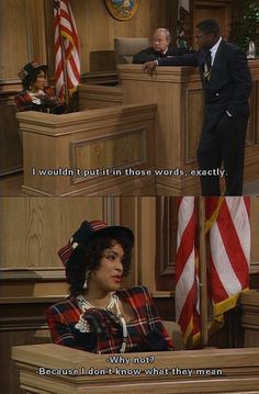 a woman sitting at a desk in front of an american flag and another man standing behind her