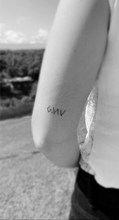 a woman with a small tattoo on her arm that reads, one and is written in cursive letters