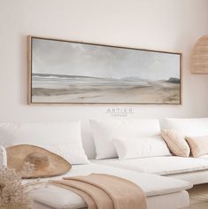 a living room with white furniture and a painting on the wall above it that says arteier canvass